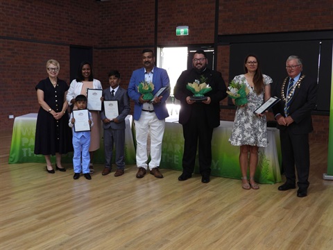 Group of people holding certificates and plants